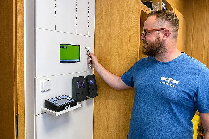 Mitarbeiter nutzt Terminal zur Zeiterfassung und Anmeldung