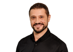 Porträt eines Mitarbeiters mit freundlichem Lächeln vor weißem Hintergrund, professionelles Businessfoto