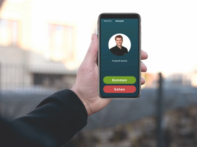 Mitarbeiter hält ein Smartphone hoch, das eine Stempelanzeige von geoCapture zeigt.