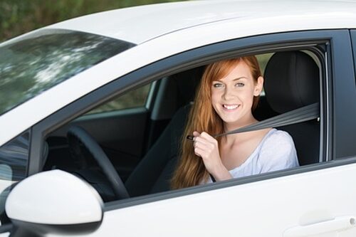 Eine Frau sitzt in einem weißen Auto, welches über einen GPS-Sender geortet wird. Damit wird ein lückenloses Fahrtenbuch geführt